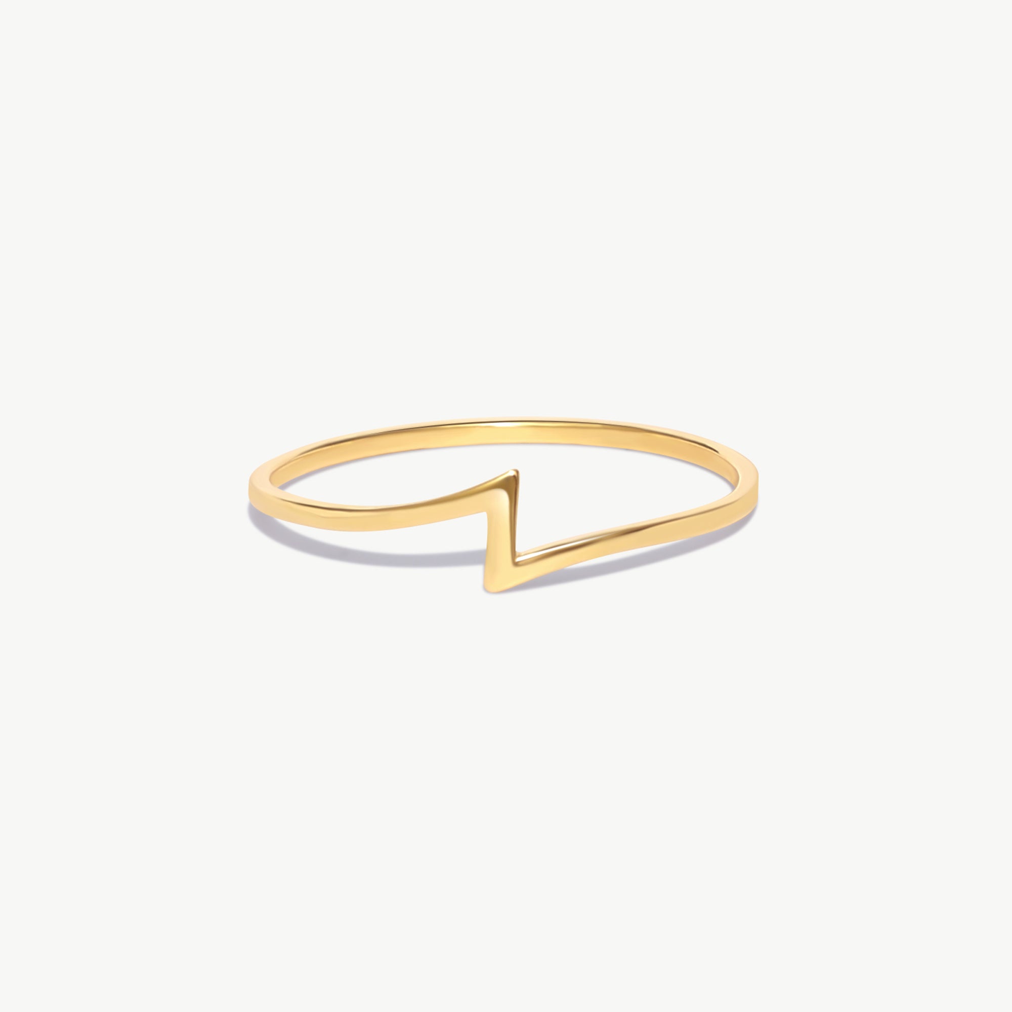 14K solid gold lightning bolt ring featuring a minimalist geometric thunder bolt silhouette crafted from polished yellow gold on a white background.