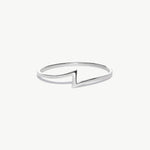 White gold minimalist lightning bolt ring photographed on a white background showcasing the thin geometric thunder bolt design.