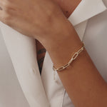 14K solid gold paperclip chain bracelet with elongated links on a wrist. A stylish and modern bracelet perfect for layering or wearing alone, suitable as a gift for her or him for special occasions.